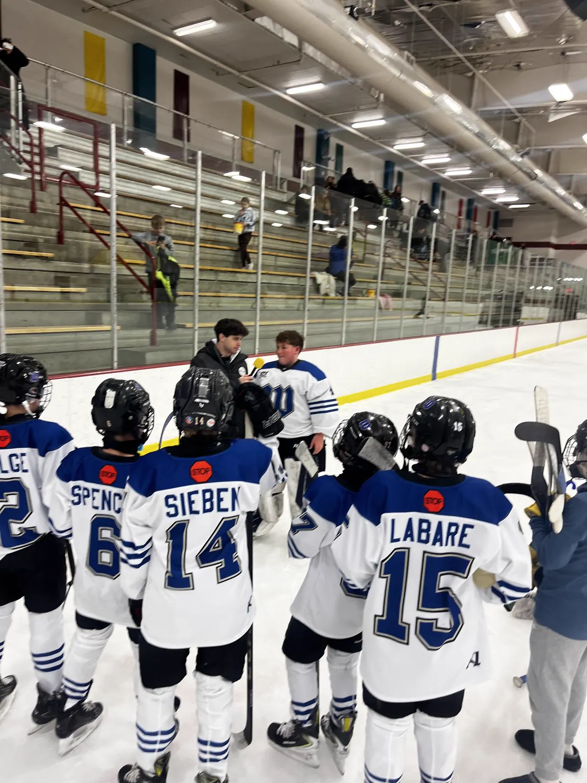 A boys team huddled together on the ice at a OneHockey tournament