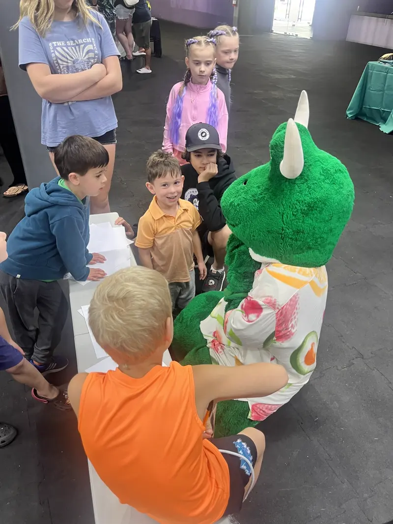 Children crowding around Freddie the OneHockey mascot at the resort