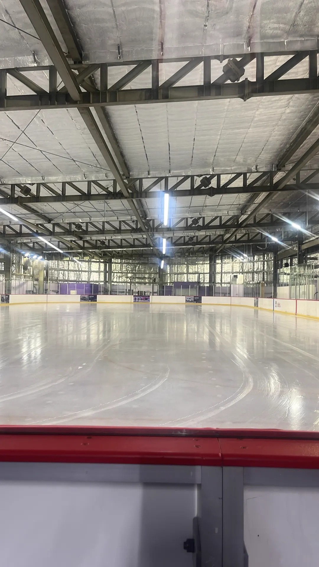 The Cancún ice surface, freshly resurfaced, seen from behind the boards